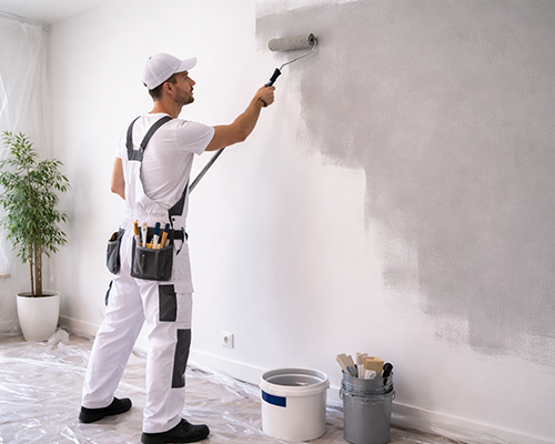 Peintre appliquant de la peinture au rouleau sur un mur